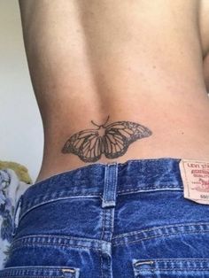 a woman's back with a butterfly tattoo on it