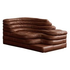 a brown leather couch sitting on top of a white floor