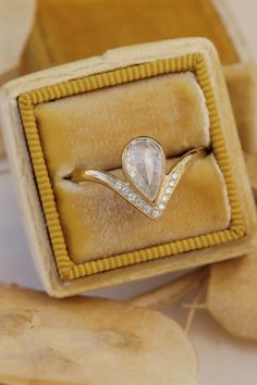 a diamond ring sits in a velvet box