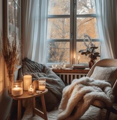 a cozy bedroom with candles and blankets on the windowsill, next to a window sill