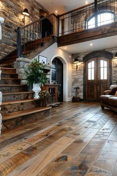 a living room filled with lots of furniture and stone wall mounted staircase leading up to the second floor