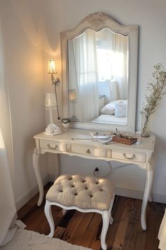 a white dressing table with a mirror and stool