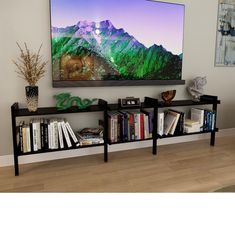 a television mounted on the wall above a book shelf filled with books and other items