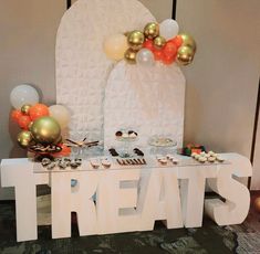 there is a dessert table with balloons and treats on the table in front of it