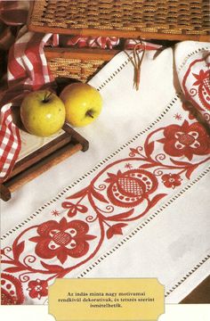 two apples are sitting on a table with red and white linens in front of them