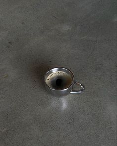 a metal strainer sitting on top of a cement floor