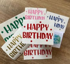 happy birthday stickers are on top of a wooden table with the words happy birthday written in red and green