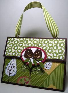 a green and white handbag with an owl on it's side, sitting on a table