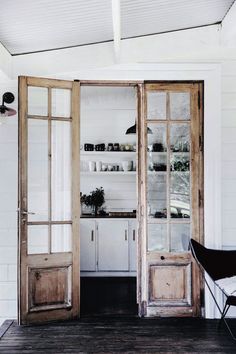 an open wooden door leading to a kitchen