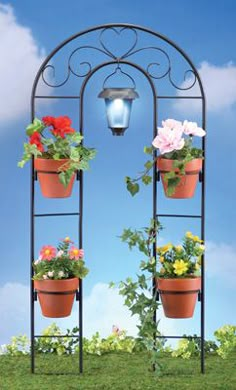 an iron plant stand with four flower pots on it and a light hanging from the top