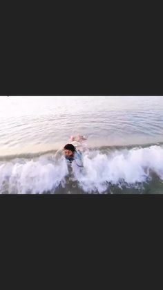 a man riding a wave on top of a surfboard in the middle of the ocean