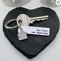 a heart shaped rock with a keychain that says new home, new beginnings