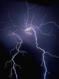 a lightning bolt is seen in the dark sky