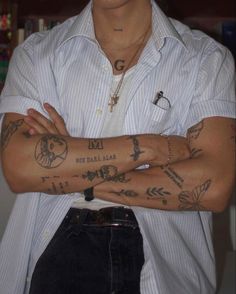 a man with tattoos on his arms and chest is posing for the camera while wearing a white shirt