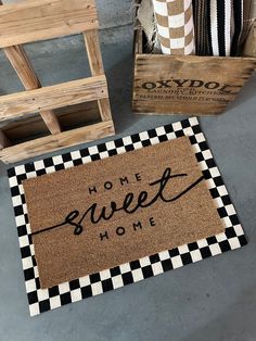 a welcome mat with the words home sweet home on it next to two wooden crates