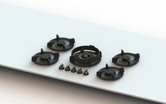 an assortment of black stove top burners on a white surface with screws and nuts