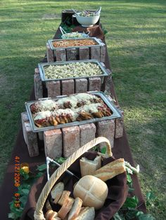 a table topped with lots of food on top of a field