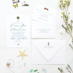 the wedding stationery is laid out on a table with flowers and seashells