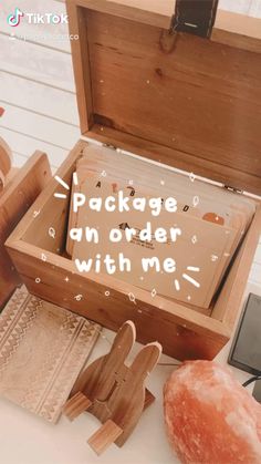 an open wooden box sitting on top of a white table next to other wood items