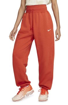 These high-rise sweats made of brushed fleece that fit loose through the hip and thigh are ready for the weekend. 29 1/2" inseam; 12" leg opening; 13" front rise; 18" back rise (size Medium) 80% cotton, 20% polyester Machine wash, tumble dry Imported Orange Sweatpants, Nike Sportswear Phoenix Fleece, Sweatpants Nike, Oversized Sweatpants, Women's Sportswear, Nike Sweatpants, Fleece Sweatpants, Active Wear Pants, Nike Store