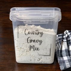 a container filled with white powder next to a black and white checkered dish towel