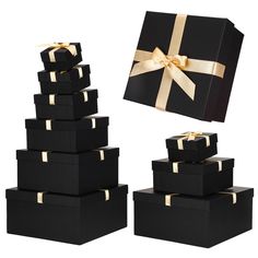 a stack of black boxes with gold ribbon and bow on top, next to the same box