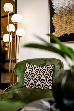 a green chair sitting next to a tall lamp