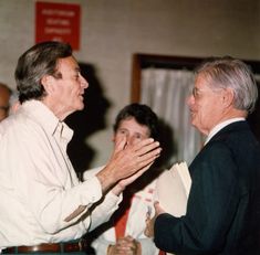 two men standing next to each other with their hands together