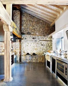 an image of a kitchen with stone walls and flooring on the appliance