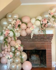 a fireplace decorated with balloons, flowers and greenery