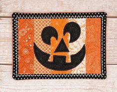 an orange and black placemat with a jack - o'- lantern on it