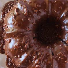 a chocolate bundt cake covered in frosting and sprinkles on a plate