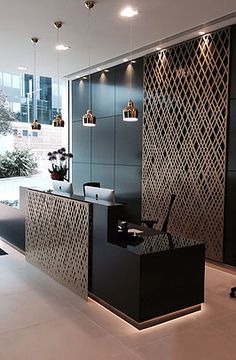 an office with black and white decor in the middle of the room is lit by recessed lights