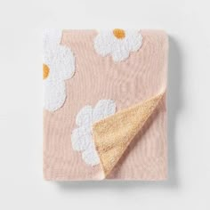 a pink blanket with white flowers on it and a yellow triangle at the bottom that is folded in half