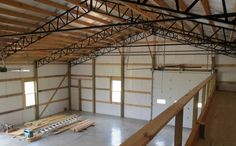 the inside of an empty warehouse with wood beams and metal bars on each side of the floor