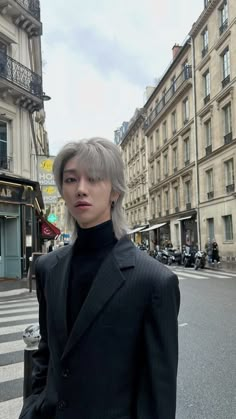 a man with grey hair standing in front of a street