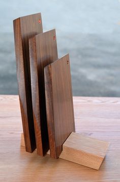 three pieces of wood sitting on top of a wooden table next to a body of water