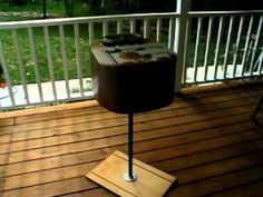 a grill on a wooden deck next to a chair