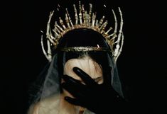 a woman wearing a crown and veil with her hands on her face