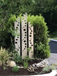 a sculpture made out of wooden boards in the middle of a garden