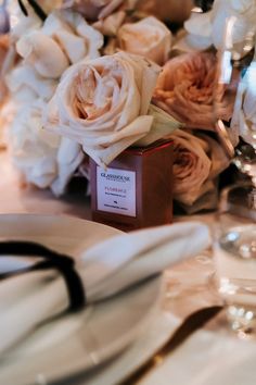 the table is set with white flowers and place settings for an elegant dinner or reception