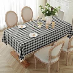 a dining room table covered with a black and white checkered tablecloth