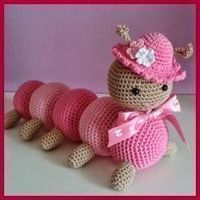 a crocheted stuffed animal with a pink hat and bow on it's head