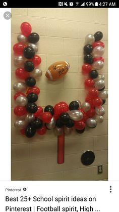 an image of balloons and footballs in the shape of a wreath on a wall