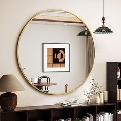 a living room with a large round mirror on the wall and bookshelves in front of it