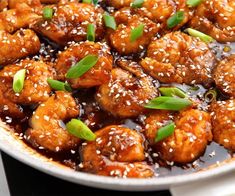 chicken with sesame seeds and seasoning in a skillet