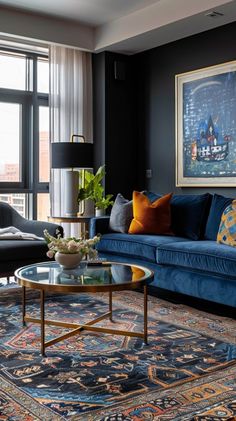 a living room filled with blue couches and furniture next to a window covered in curtains