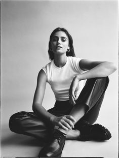 a black and white photo of a woman sitting on the floor