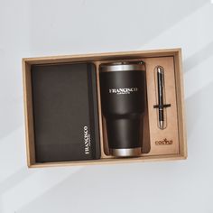 a black coffee cup and pen in a wooden box