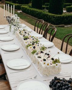 a long table with plates and flowers on it